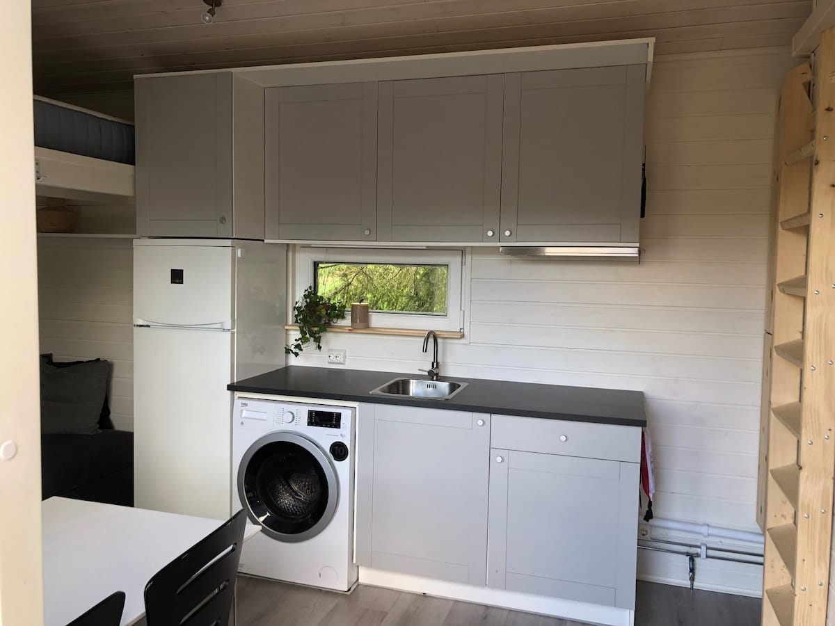 Köksbänken med diskhoar och tvättmaskin.