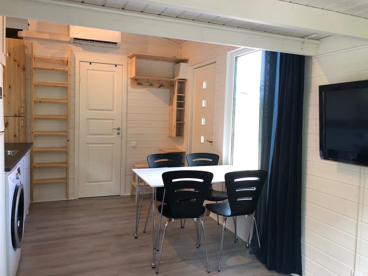 Matbord för fyra med fönster mot skogen.